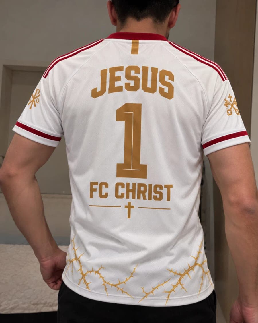 Le maillot porté de dos devant un miroir : « JESUS », le 1 et « FC CHRIST » sublimés en or.